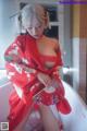 A woman in a red kimono sitting on a bathtub.