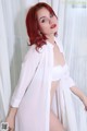 A woman with red hair wearing a white shirt and panties.