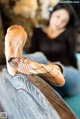 A woman in fishnet stockings sitting on a couch.