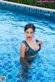 A woman in a blue bikini standing in a pool.