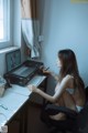 A woman sitting at a desk with a laptop computer.