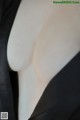 A close up of a woman's breasts in a black dress.