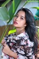 A woman with long black hair wearing a floral dress.