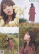 A woman in a red dress standing in a field of flowers.