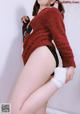 A woman in a red sweater and black panties posing for a picture.