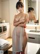 A woman standing in a kitchen next to a sink.