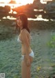 A woman in a white bikini standing on a beach.