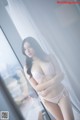 A woman in a white lingerie posing in front of a mirror.